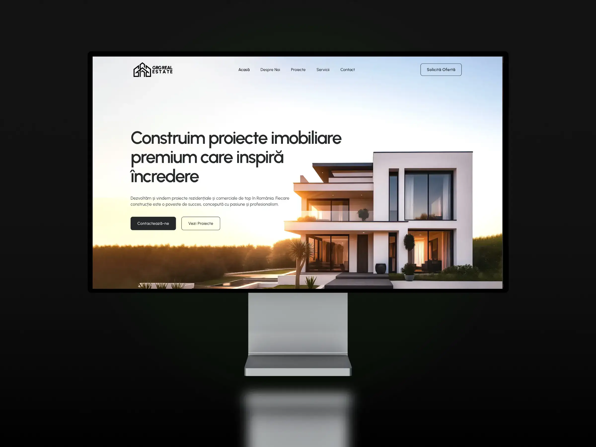 Prima pagină a site-ului GRG Real Estate, cu o casă modernă în imaginea mare, pe un monitor